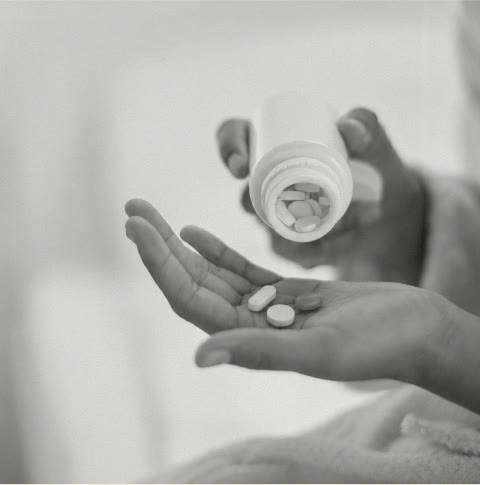 Pillen aus der Dose in die Hand